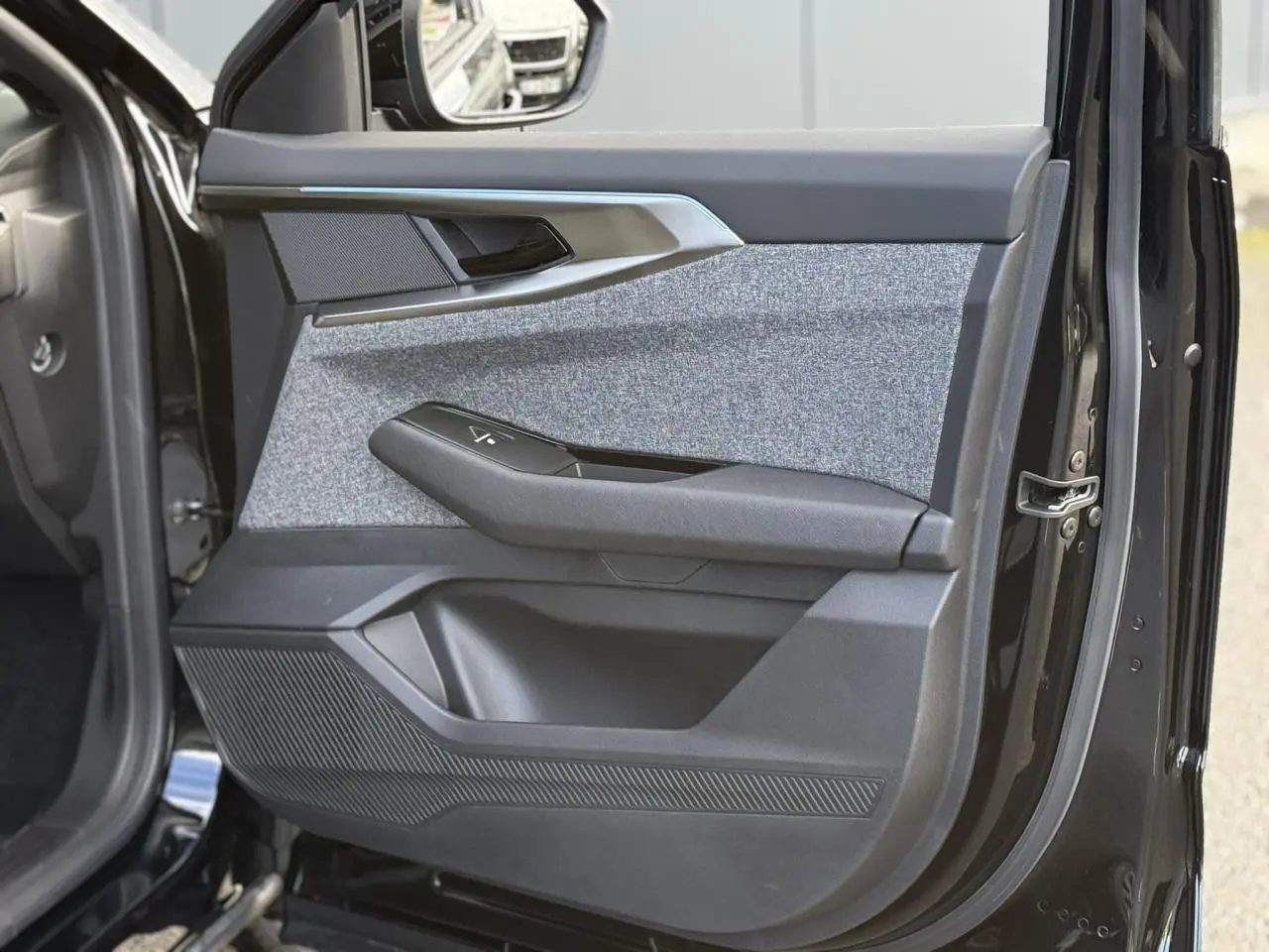 Gros plan sur la porte avant gauche du Renault Espace VI noir étoilé, avec garniture grise et insert chromé.