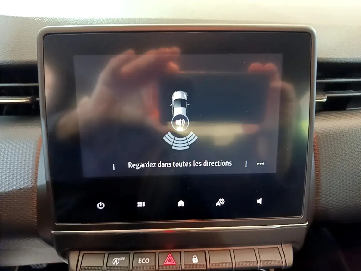 Écran tactile central de la Renault Clio Business blanc 2020 affichant l'alerte de surveillance des angles morts.
