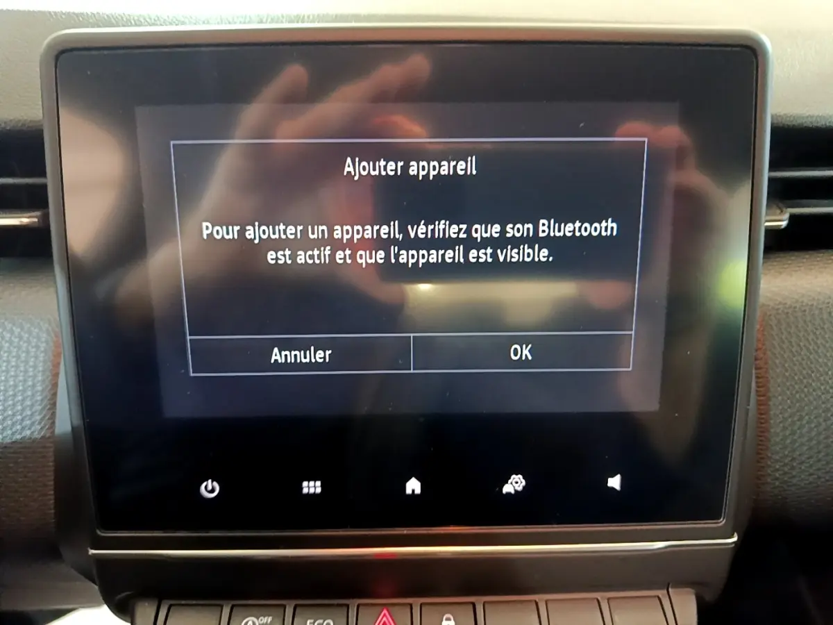 Écran tactile central affichant un message Bluetooth dans l'habitacle d'une Renault Clio Business blanche de 2020.
