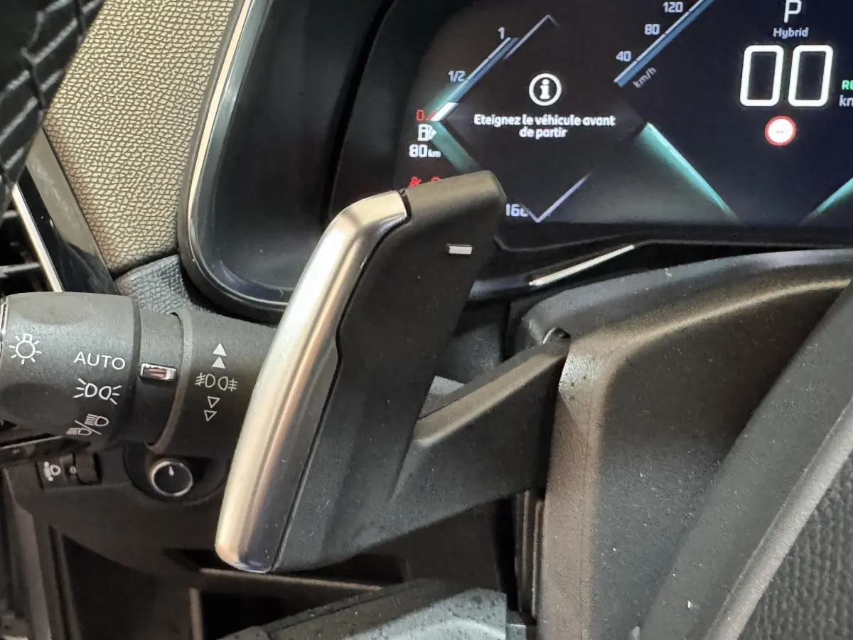 Gros plan sur la commande de boîte automatique et le tableau de bord digital du DS7 Crossback gris foncé, version E-TENSE 225 Bastille+.