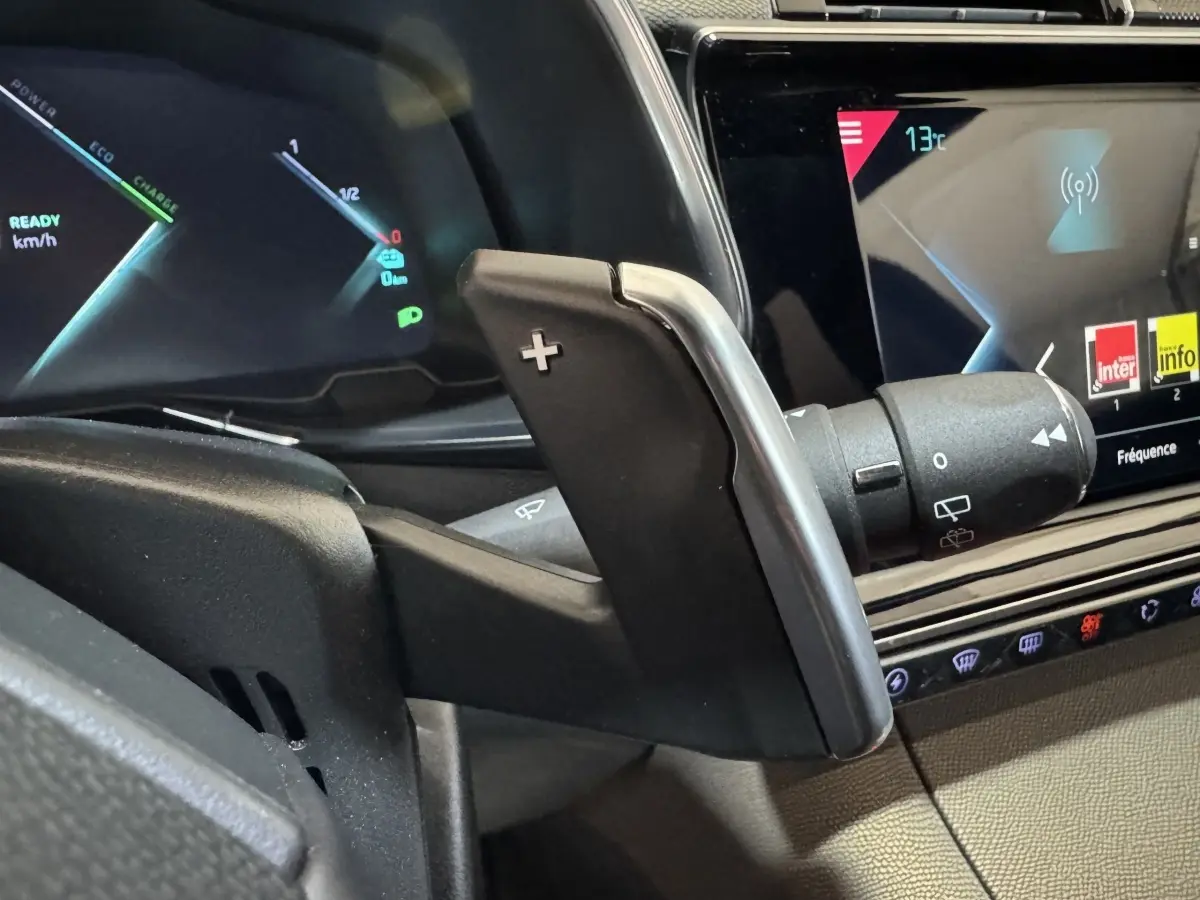 Gros plan sur la palette de changement de vitesse droite et l’écran tactile du tableau de bord du DS7 Crossback E-TENSE gris foncé.