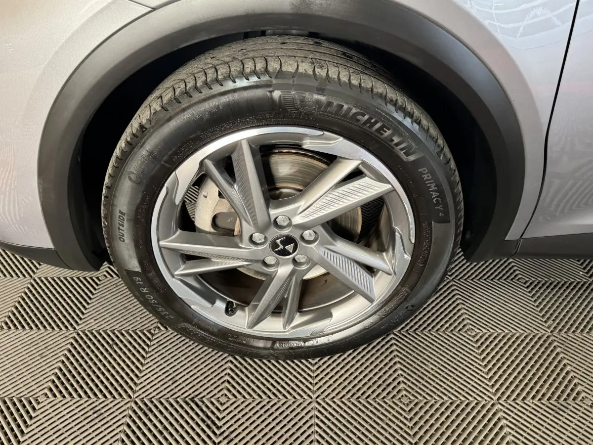 Gros plan sur la roue avant droite gris foncé du DS7 Crossback E-TENSE 225 BASTILLE + avec jante alliage et pneu Michelin.