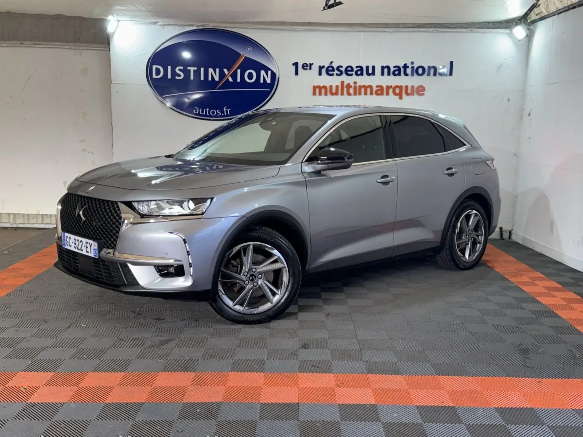DS7 Crossback E-TENSE gris foncé vu en 3/4 avant droit, avec calandre distinctive et jantes alliage modernes.