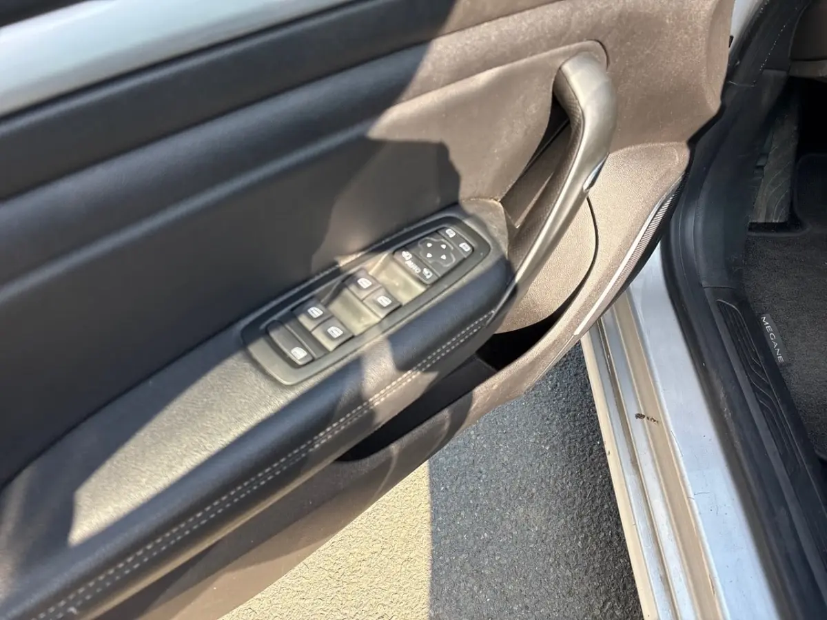Vue rapprochée de la porte avant gauche de la Renault Mégane 2020, avec commandes de vitres et seuil de porte argenté.