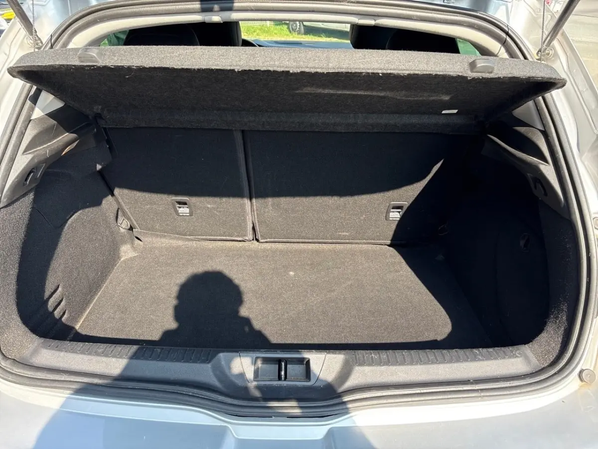Coffre ouvert de Renault Mégane Intens Blue dCi 115 gris, vue arrière montrant l’espace de chargement vide.