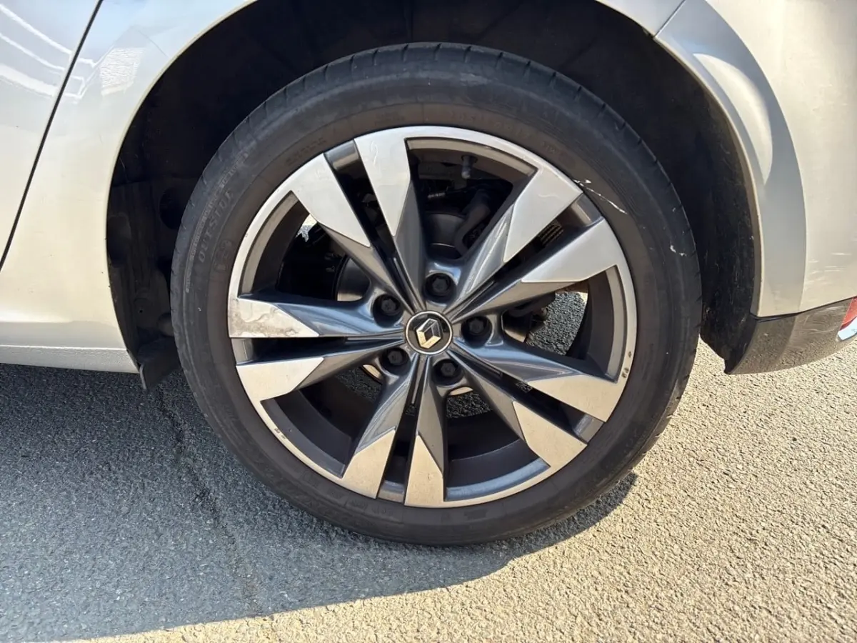 Gros plan sur la roue avant droite argentée avec jante alliage au design moderne d'une Renault Mégane 2020.