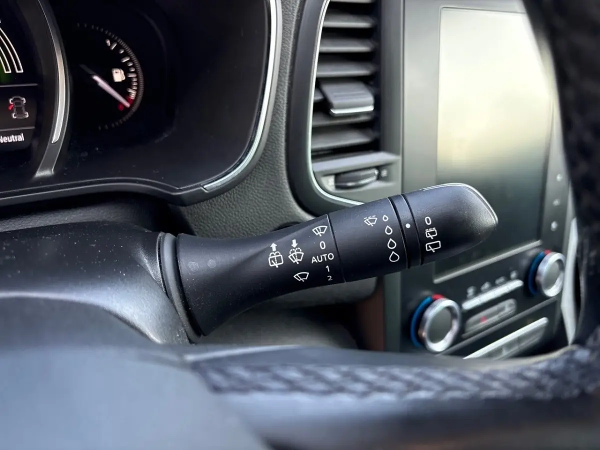 Gros plan sur la commande d’essuie-glace noire à gauche du volant dans l’habitacle de la Renault Mégane Intens 2020.