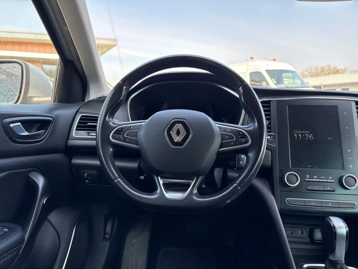 Vue intérieure centrée sur le volant cuir noir et l'écran tactile vertical du tableau de bord de la Renault Mégane 2020.
