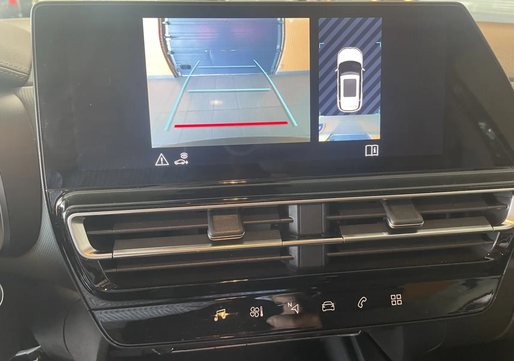 Écran tactile intérieur du Citroën C5 Aircross hybride 2025 montrant la caméra de recul et l'aide au stationnement.