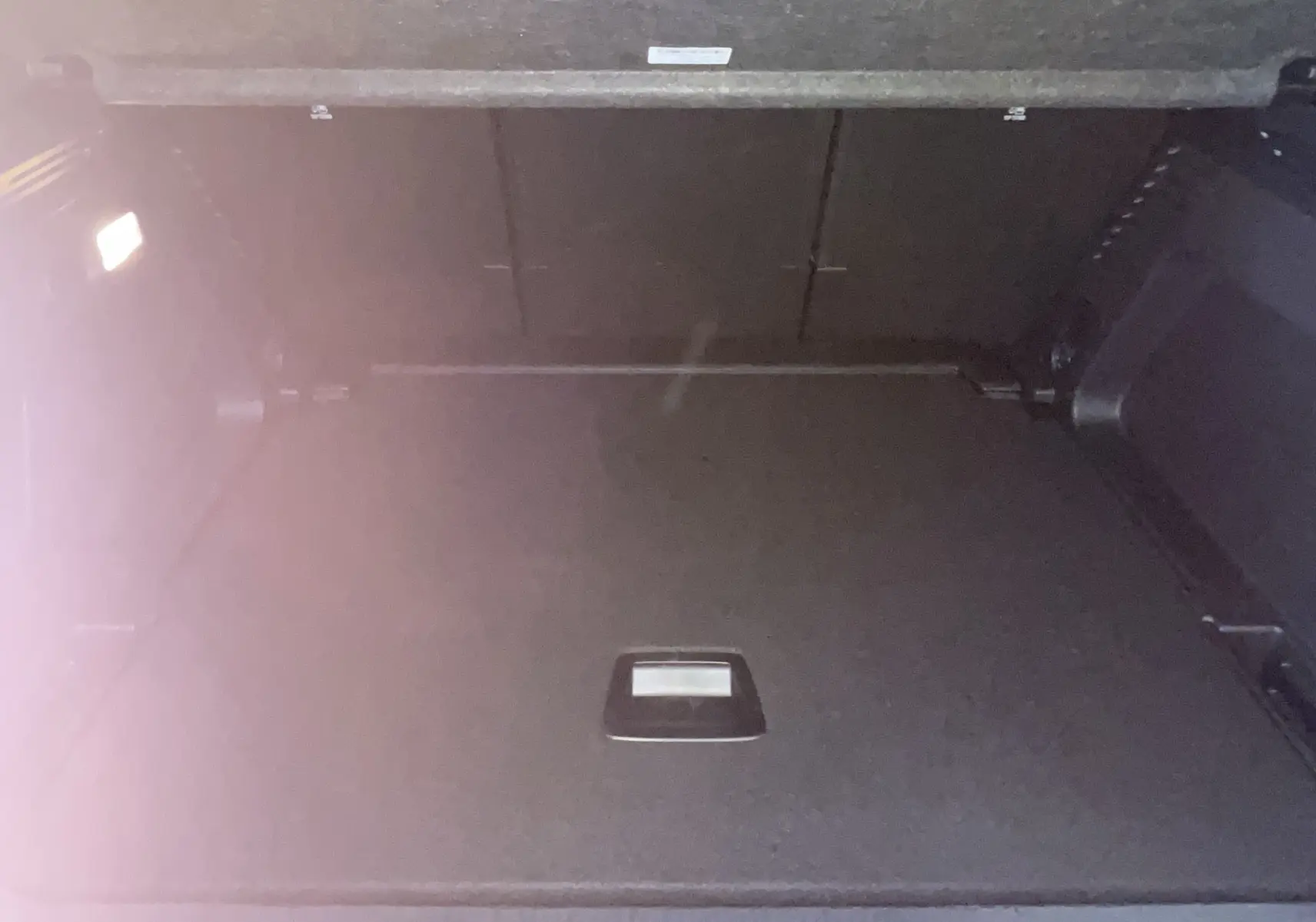Coffre ouvert vu de face du Citroën C5 Aircross hybride 2025, espace de chargement sombre et spacieux.