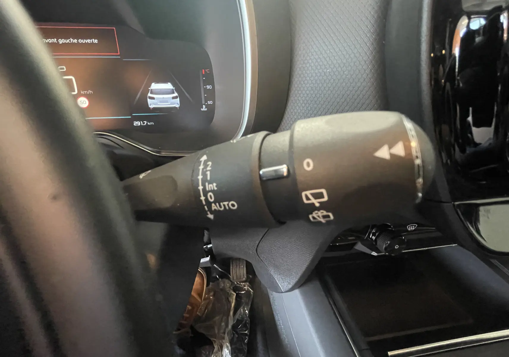 Gros plan sur la commande d'essuie-glace à gauche du volant dans le tableau de bord d'un Citroën C5 Aircross hybride bleu foncé 2025.