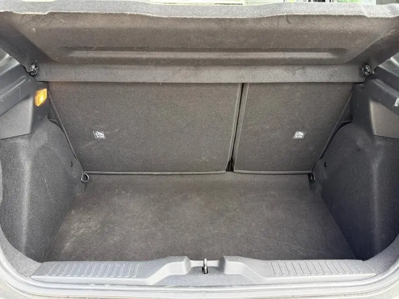 Coffre ouvert vu de l'arrière d'une Citroën C3 1.2 Turbo 100ch gris Mercury, intérieur noir et tapis propre.