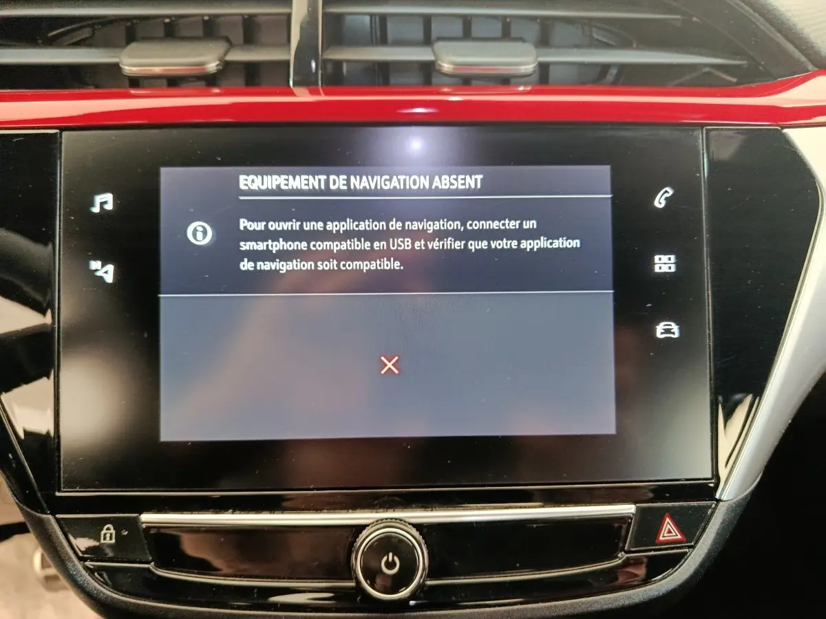 Écran tactile central de la console d’une Opel Corsa rouge 2023 affichant un message d’équipement de navigation absent.