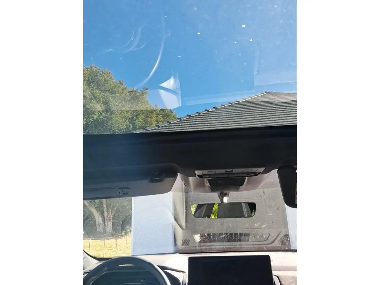 Vue intérieure du toit ouvrant panoramique et tableau de bord du Nissan Qashqai 2024 rouge foncé Tekna.