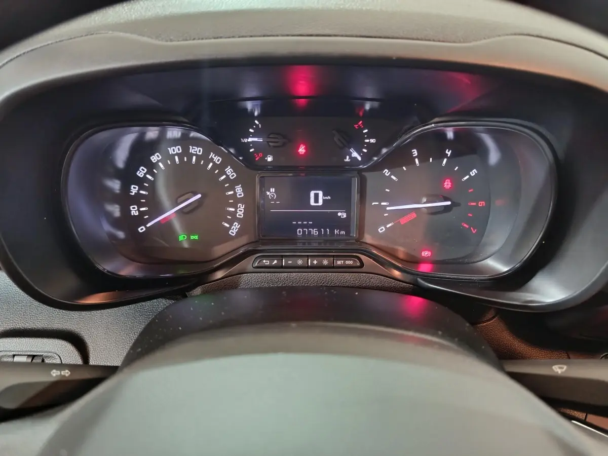 Vue rapprochée du tableau de bord du Citroën Berlingo blanc 2021 avec compteur digital et voyants allumés.