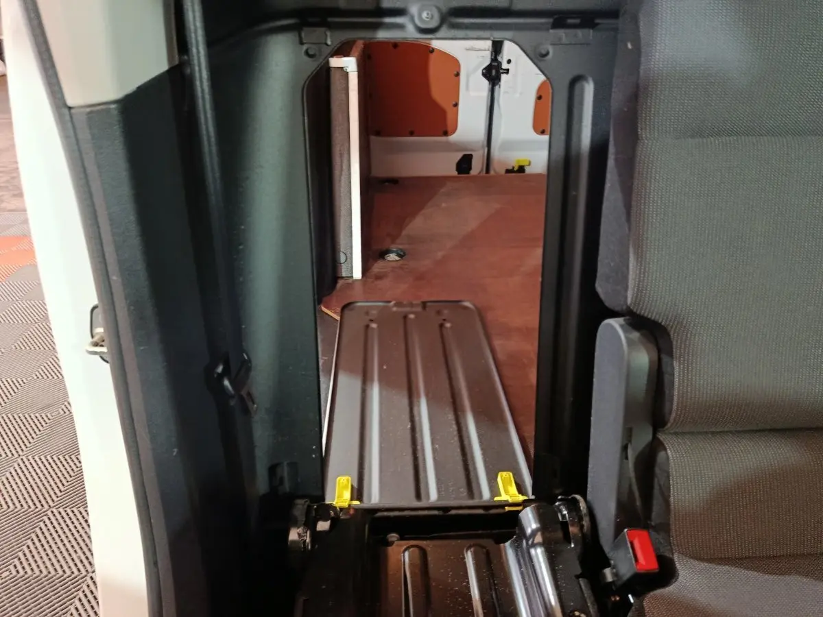 Vue intérieure du passage entre cabine et espace de chargement du Citroën Berlingo blanc, avec cloison pleine visible.