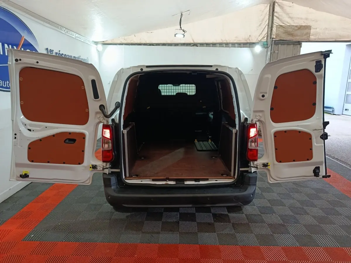 Vue arrière du Citroën Berlingo blanc 2021 avec portes ouvertes dévoilant l'espace de chargement vide et cloison pleine.