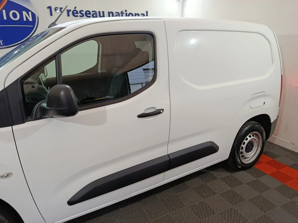 Vue latérale côté droit d'un utilitaire Citroën Berlingo blanc avec porte latérale pleine et jantes acier.