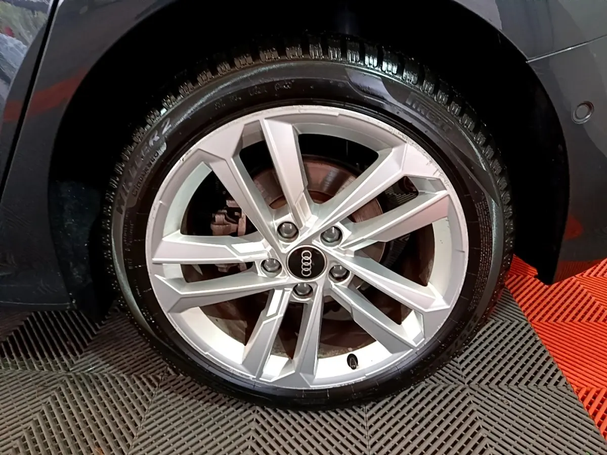 Gros plan sur la roue avant droite gris foncé d'une Audi A3 35 TFSI 150 MHEV avec jante aluminium à 5 branches doubles.