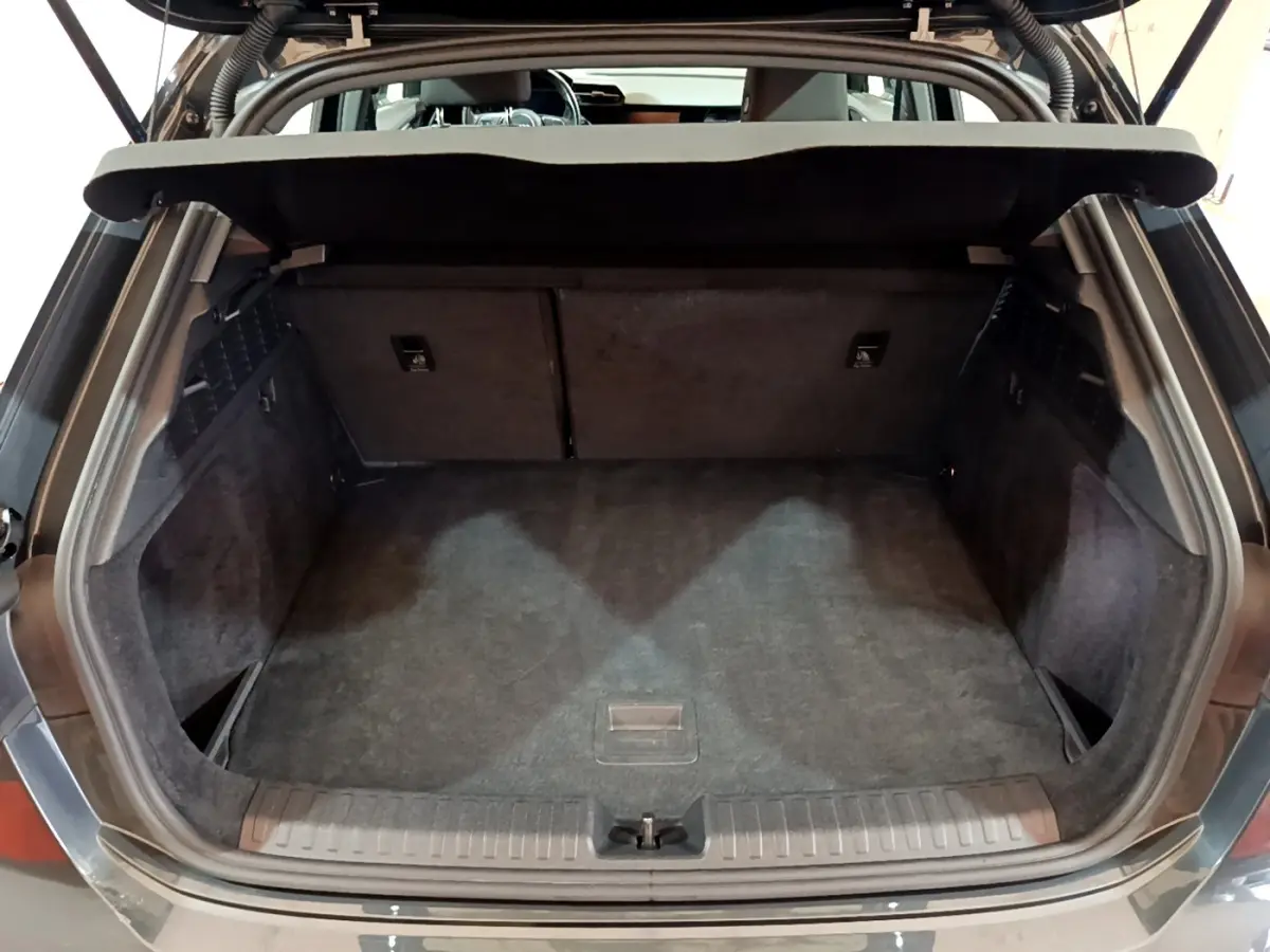 Coffre ouvert vu de l'arrière d'une Audi A3 gris foncé, montrant un espace de chargement propre et spacieux.