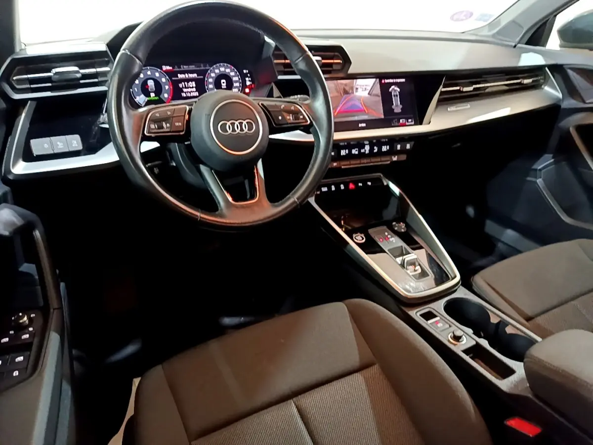 Vue intérieure de l'Audi A3 35 TFSI 2021, tableau de bord et volant cuir noir avec écran tactile et affichage numérique.