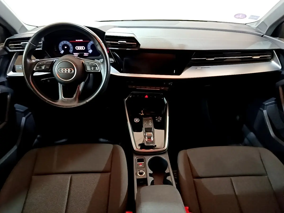 Vue intérieure avant de l'Audi A3 35 TFSI 2021, tableau de bord moderne avec volant cuir et console centrale noire brillante.