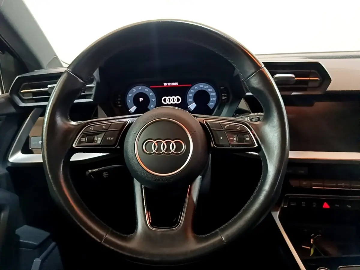 Vue centrée sur le volant cuir noir et le tableau de bord numérique d'une Audi A3 Business Line 2021.