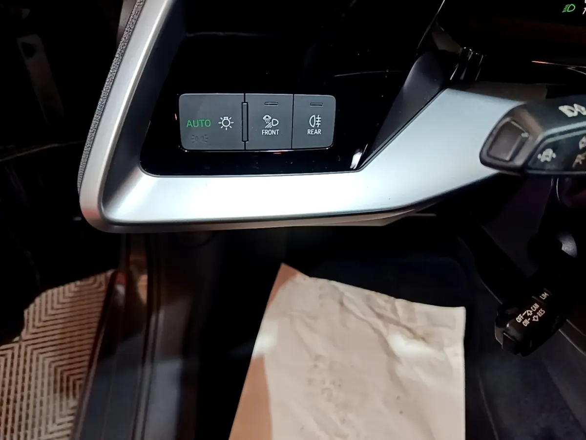 Vue rapprochée du panneau de commandes d’éclairage à gauche du volant dans l’Audi A3 gris foncé 2021.