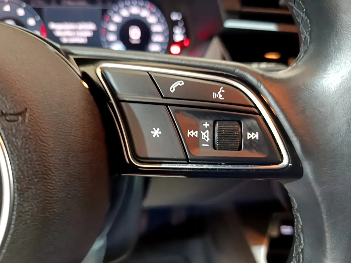 Gros plan sur les commandes multifonctions côté droit du volant cuir noir d’un Audi A3 35 TFSI 2021.