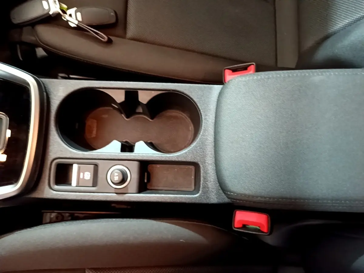 Vue plongeante sur la console centrale noire de l'Audi A3 35 TFSI 2021 avec porte-gobelets et accoudoir tissu.