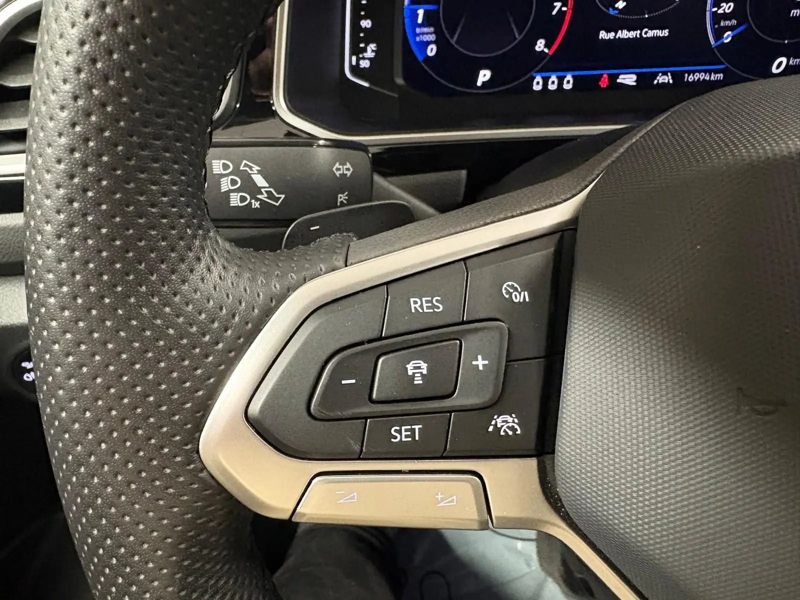 Gros plan sur le volant perforé du Volkswagen T-Roc 1.5 TSI 150 DSG7 R-Line Edition avec commandes de régulateur de vitesse.