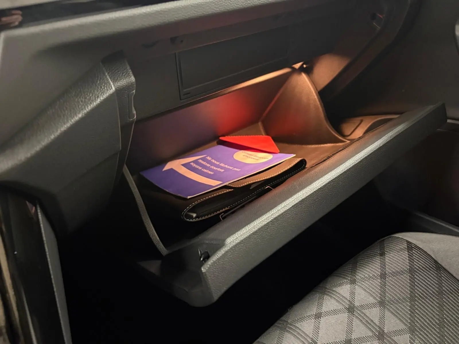 Gant de boîte à gants ouvert côté passager avec documents et sellerie tissu gris à motifs dans Volkswagen T-Roc.