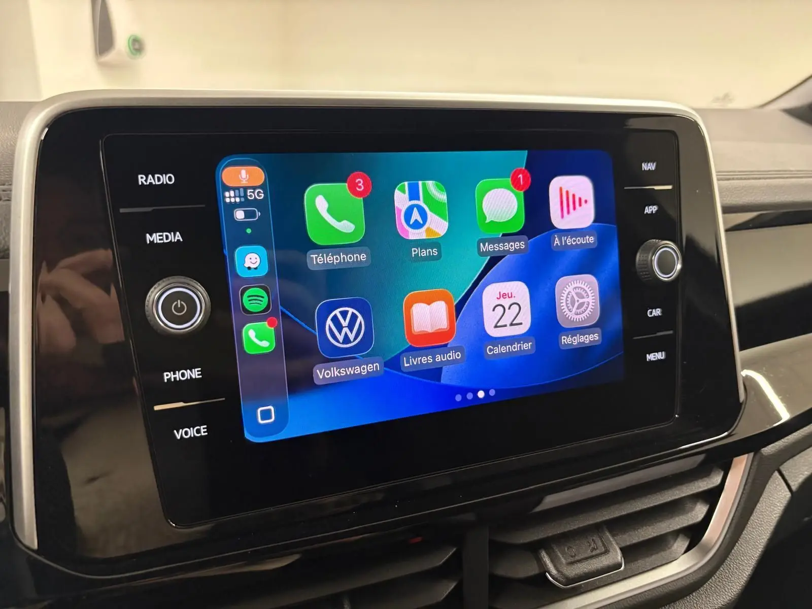 Écran tactile central du Volkswagen T-Roc 2025 affichant l'interface Apple CarPlay, vue de face intérieure.