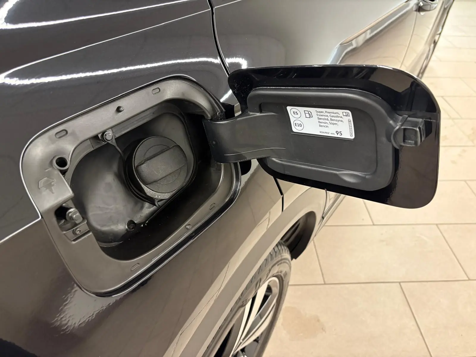 Volkswagen T-Roc noir intense en 3/4 avant droit, avec jantes alliage et phares LED allumés dans un intérieur neutre.