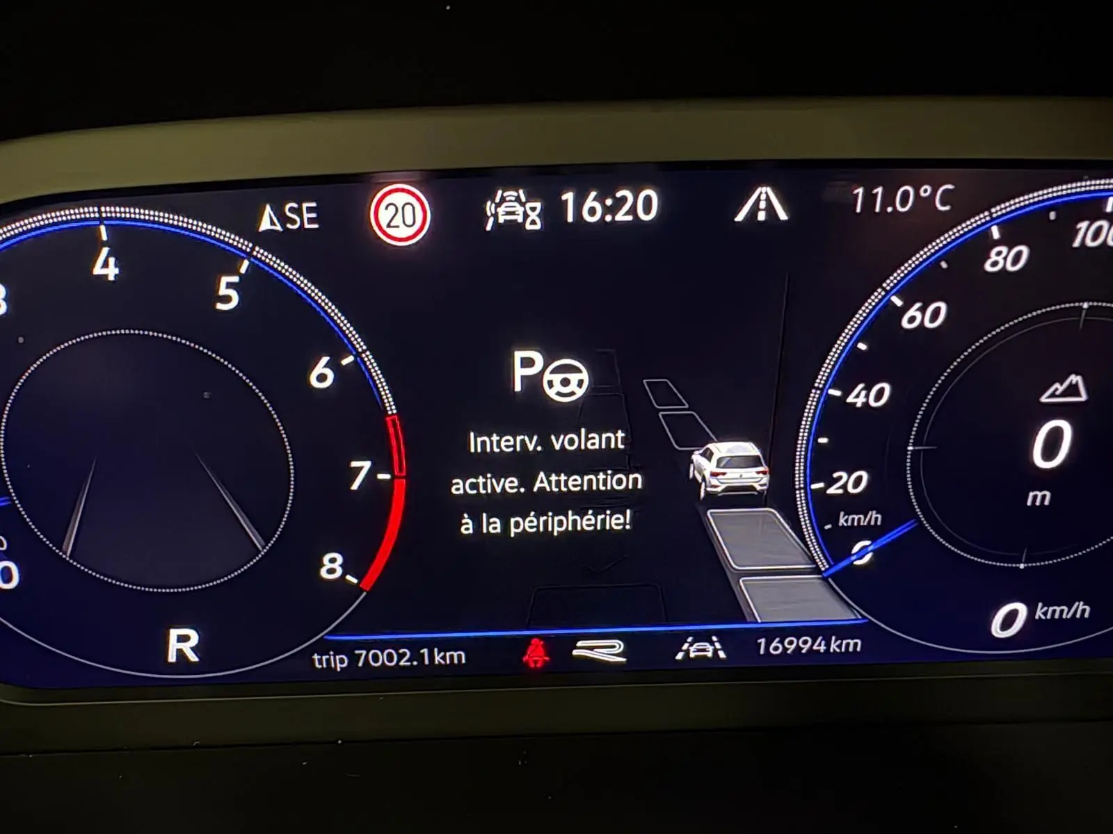 Tableau de bord numérique du Volkswagen T-Roc 2025 affichant une alerte d'assistance au volant, vitesse et température.