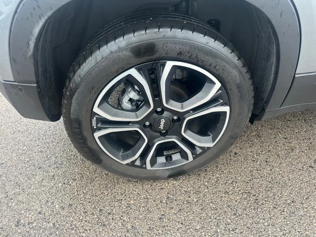 Gros plan sur la roue avant gauche du Jeep Avenger gris foncé avec jante alliage 18 pouces au design moderne.