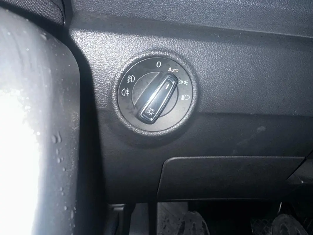 Gros plan sur le bouton de réglage des phares dans l'habitacle noir du Jeep Avenger 2025.