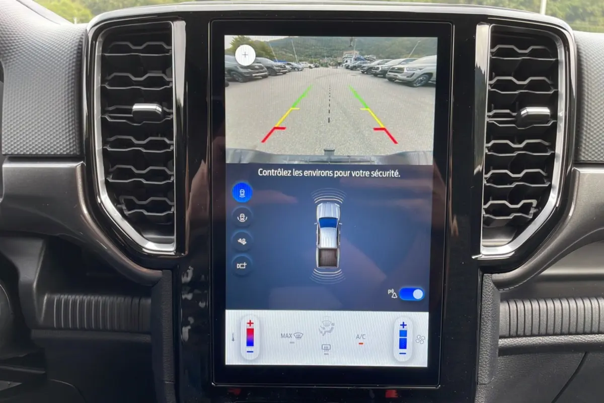 Vue rapprochée de l’écran tactile central du Ford Ranger gris carbone, affichant la caméra de recul et l’aide au stationnement.