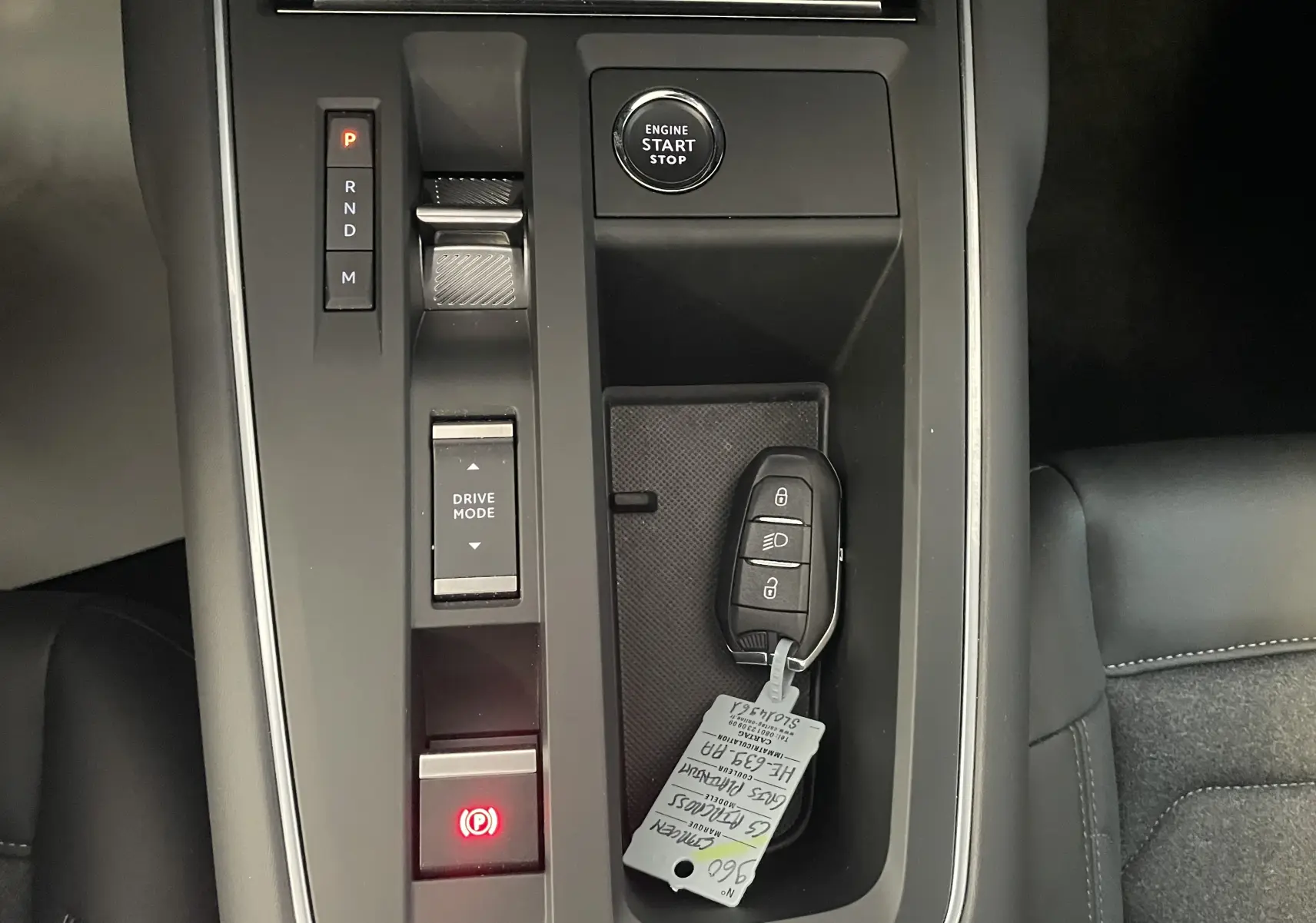 Vue rapprochée de la console centrale du Citroën C5 Aircross hybride 2025, avec clé et bouton start/stop visibles.
