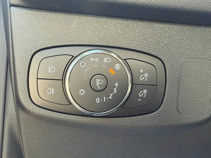 Gros plan sur le bouton de commande des phares du Ford Focus SW 2023, finition ST-Line X, intérieur noir texturé.