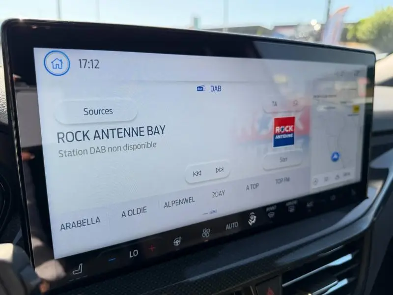 Écran tactile central de la Ford Focus SW 2023 affichant la radio DAB et la navigation, intérieur moderne noir.