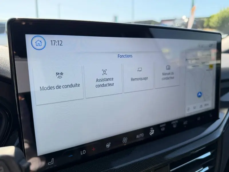 Écran tactile central du tableau de bord de la Ford Focus SW 2023, affichant les fonctions d'assistance et modes de conduite.