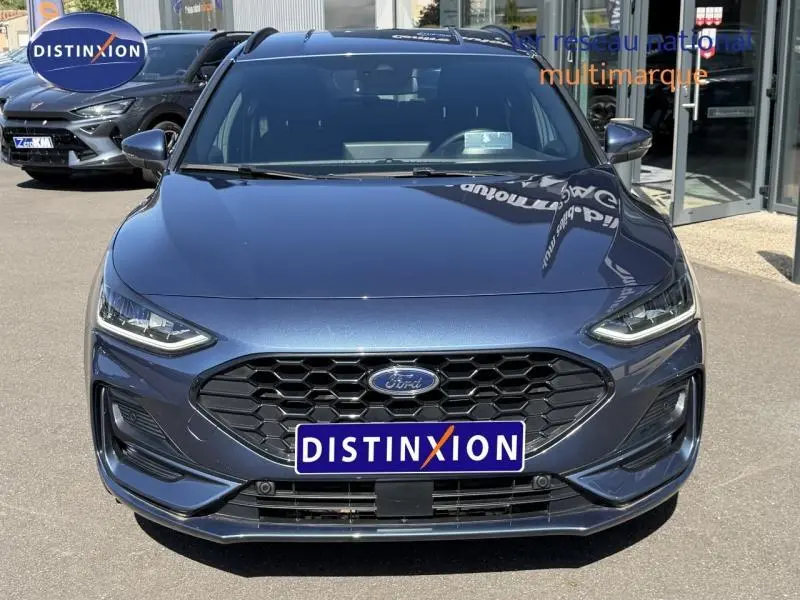 Vue avant d'une Ford Focus SW 2023 Bleu Azur métallisé avec calandre hexagonale et logo Ford visible.
