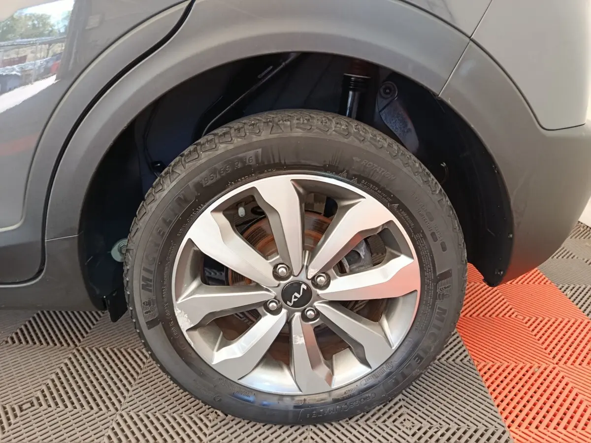 Gros plan sur la roue avant droite d’un KIA STONIC gris foncé, avec jante alliage et pneu Michelin visible.