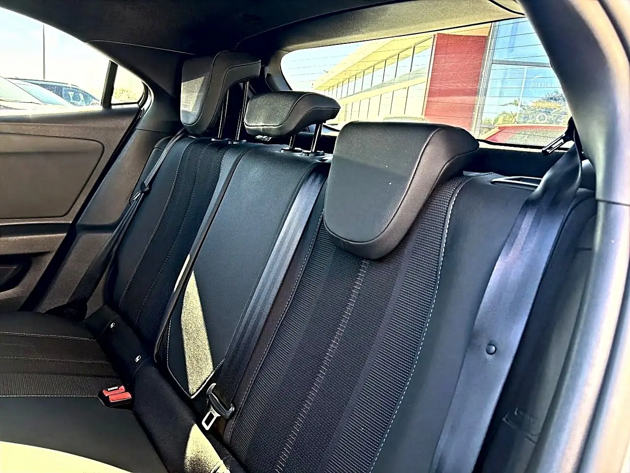 Vue intérieure de la banquette arrière noire de l'Opel Mokka Electric 156 gs 2025, avec appuie-têtes et ceintures visibles.