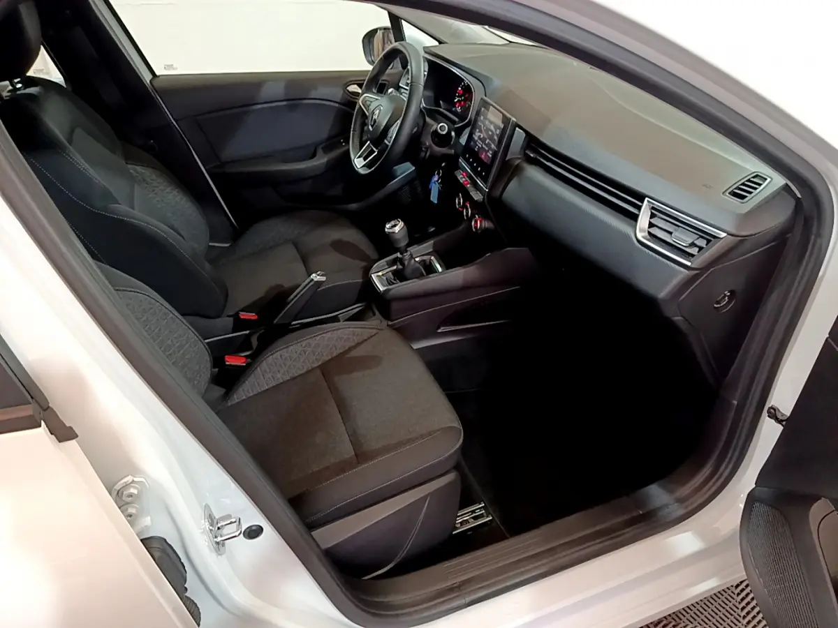 Intérieur de la Renault Clio Business Blue dCi 85 blanc, vue côté conducteur avec tableau de bord et sièges noirs.