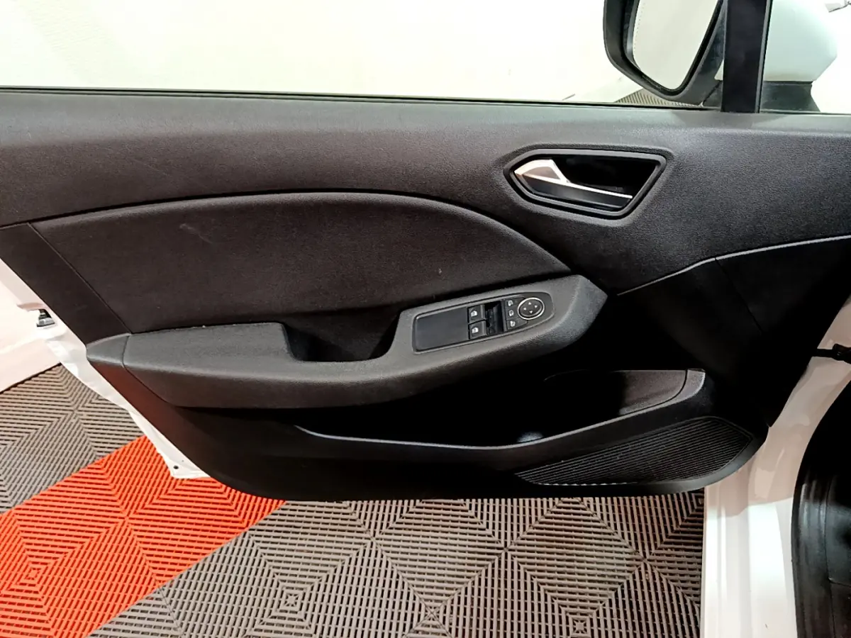 Porte avant droite ouverte d'une Renault Clio Business Blue dCi 85 blanche, montrant le panneau de porte noir avec commandes électriques.