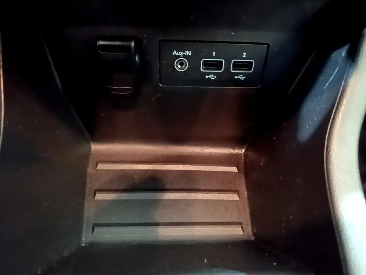 Gros plan sur la console centrale noire de la Renault Clio Business Blue dCi 85, montrant ports USB et prise Aux-In.