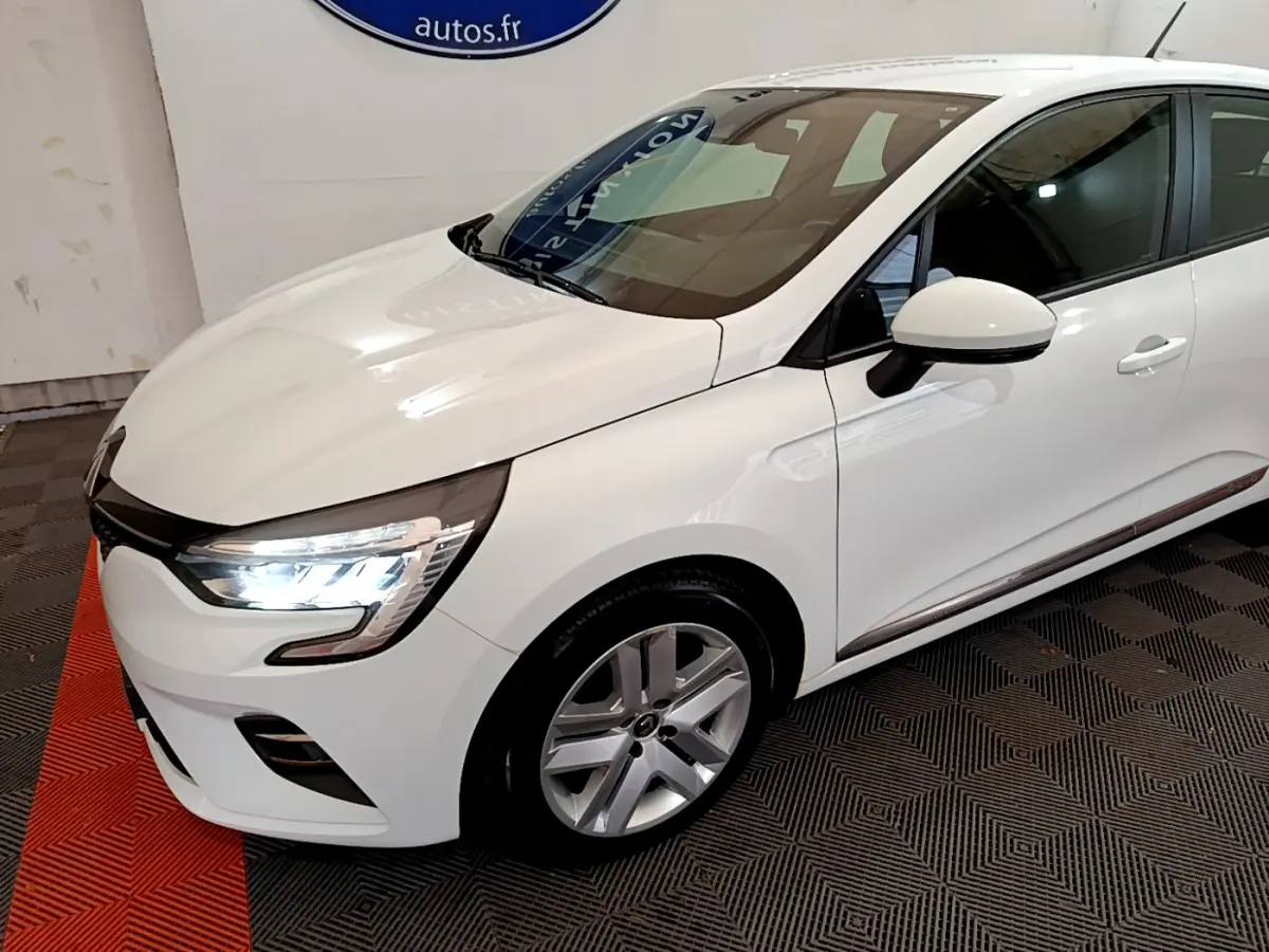 Renault Clio Business Blue dCi 85 blanche vue en 3/4 avant droit, avec phares LED allumés et jantes alliage.
