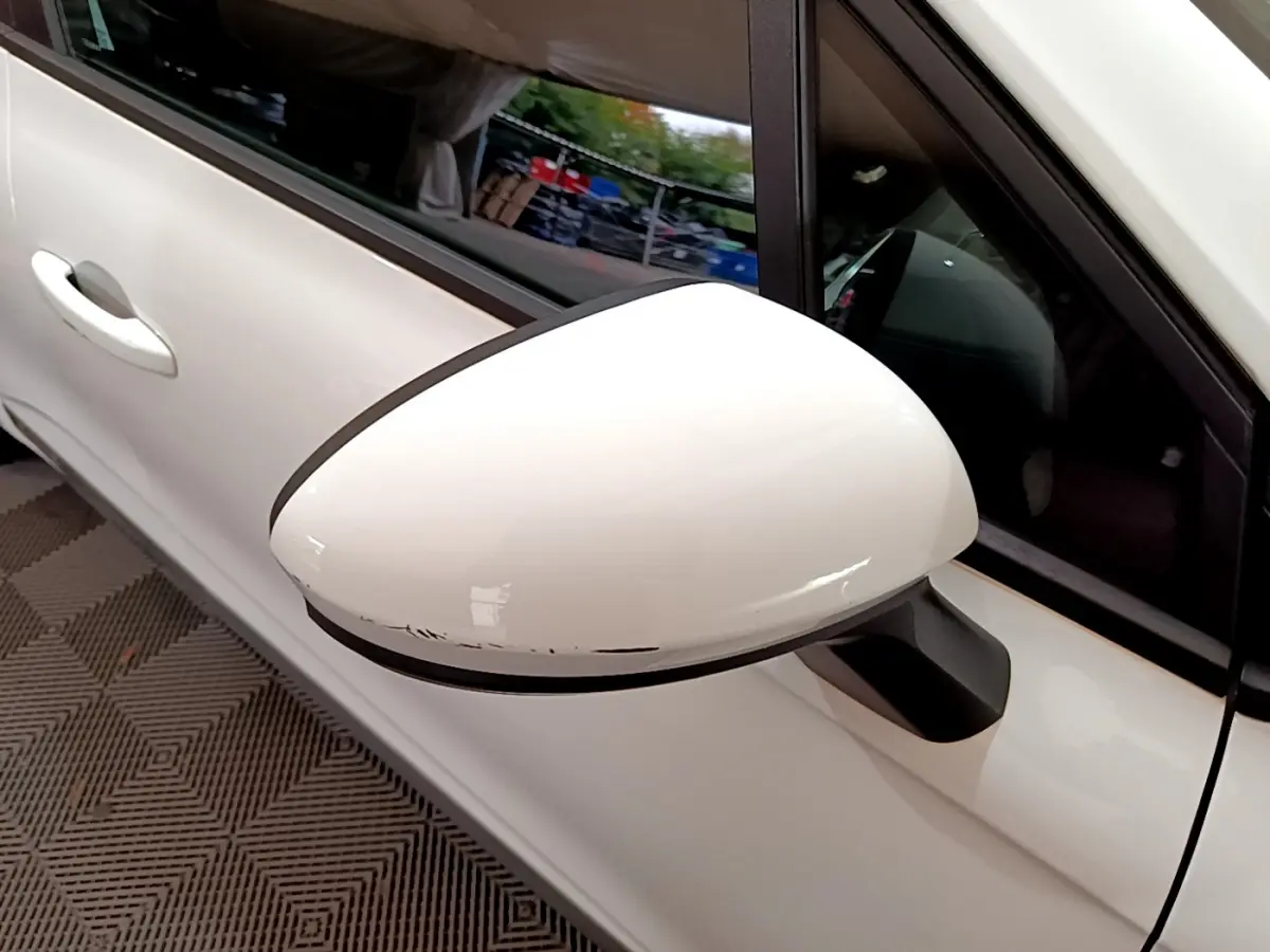 Rétroviseur côté gauche blanc de Renault Clio Business Blue dCi 85 2020 avec rayures visibles sur le bord inférieur.